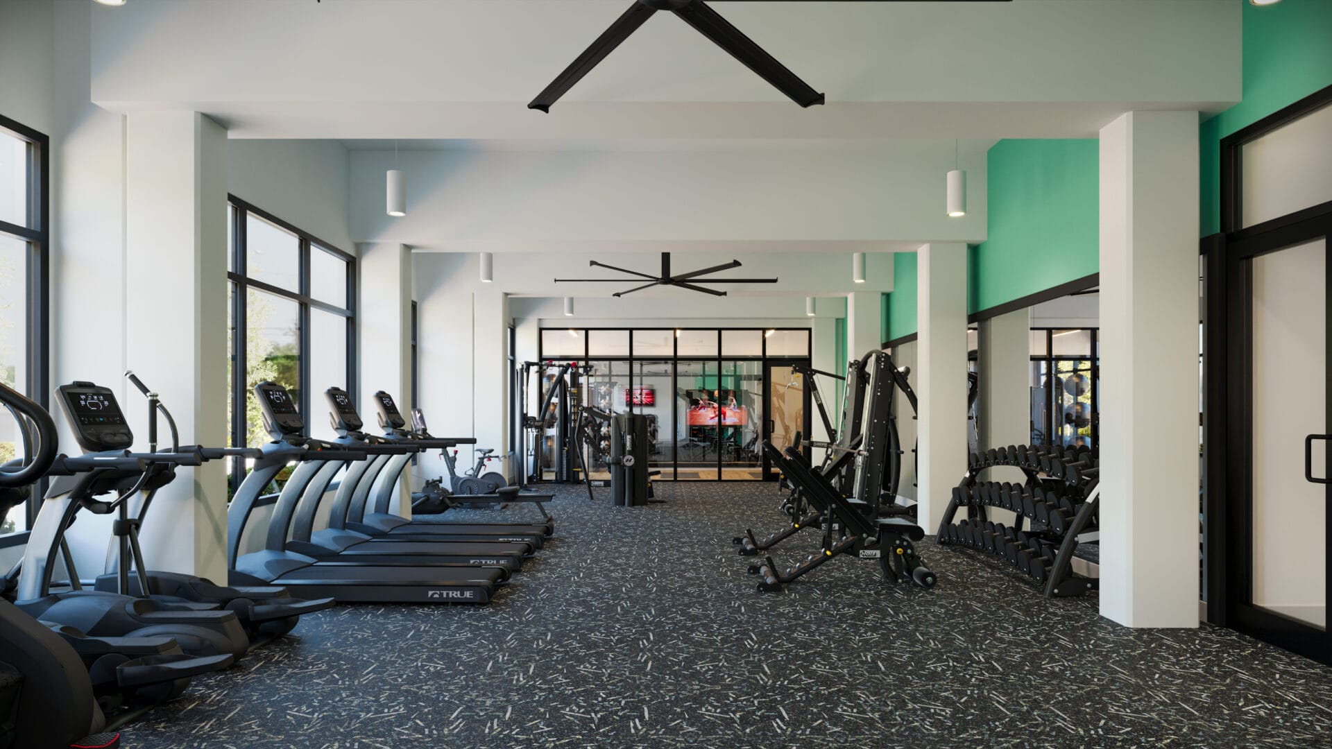 A gym with many different machines and a ceiling fan.